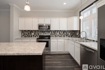 North Mankato apartment for rent - A kitchen with white cabinets and a marble countertop.