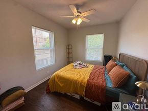 Chicago apartment for rent - A bedroom with a bed covered in a yellow and orange comforter.
