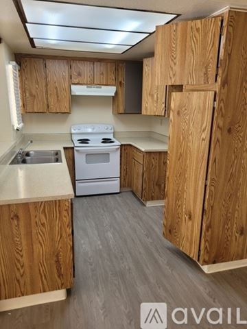 Moreno Valley apartment for rent - A kitchen with wooden cabinets and a white stove top oven.