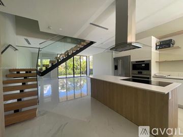 Key Biscayne house for rent - A modern kitchen with a wooden counter and stainless steel appliances.