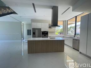 Key Biscayne house for rent - A modern kitchen with a wooden island in the middle.