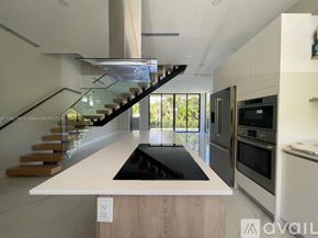 Key Biscayne house for rent - A modern kitchen with a staircase leading to the upper level.
