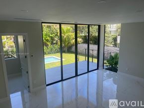 Key Biscayne house for rent - A room with a view of a pool and greenery outside.