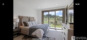 Heber City townhouse for rent - A bedroom with a large bed and a view of the countryside through the window.
