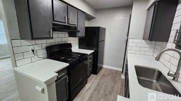 Dallas apartment for rent - A kitchen with black cabinets and a white countertop.