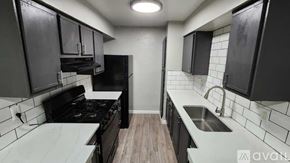 Dallas apartment for rent - A kitchen with black cabinets and a white countertop.