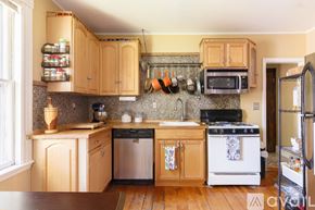Salem condo for rent - A kitchen with wooden cabinets and a stove top oven.