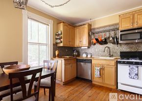 Salem condo for rent - A kitchen with wooden cabinets and a dining table.