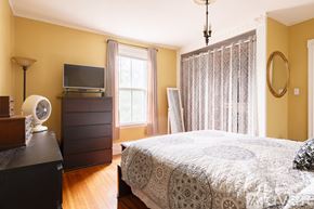 Salem condo for rent - A bedroom with a bed, a dresser, and a window with curtains.