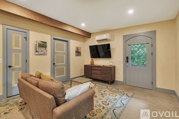 Atlanta house for rent - A living room with a brown couch and a flat screen TV mounted on the wall.