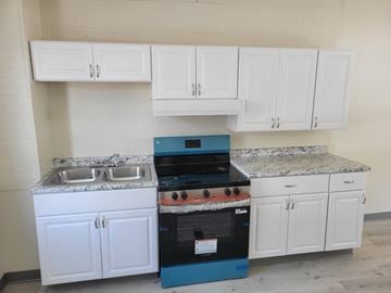 Glassport apartment for rent - A kitchen with white cabinets and a blue oven.