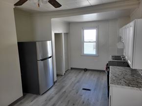 Glassport apartment for rent - A kitchen with a black fridge and a wooden floor.