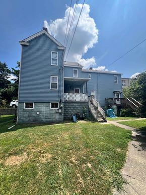 Glassport apartment for rent - A two-story house with a blue exterior and a white car parked in the driveway.