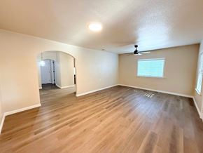 Merced house for rent - A room with wooden flooring and a ceiling fan.