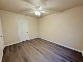 Merced house for rent - A room with a white door and a ceiling fan.