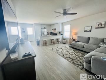 Bulverde house for rent - A living room with a grey couch and a ceiling fan.