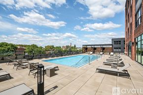 Chicago apartment for rent - A pool area with sun loungers and a building in the background.