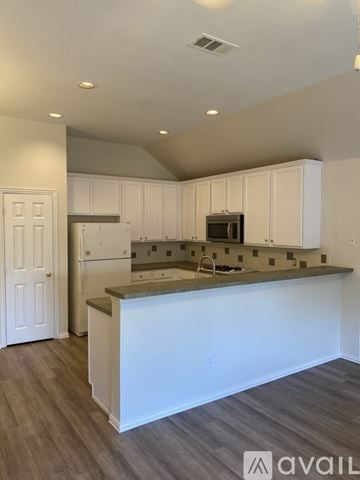 Mc Kinney house for rent - A kitchen with white cabinets and a countertop.