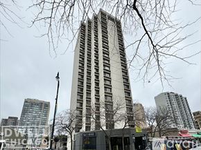Chicago apartment for rent - A tall building stands in front of a bus stop.