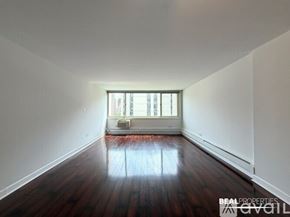 Chicago condo for rent - A room with wooden floors and a window is available for rent.