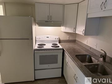 Pensacola apartment for rent - A white stove and refrigerator in a kitchen with white cabinets.