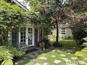 San Diego house for rent - A small white house with a porch surrounded by green plants.