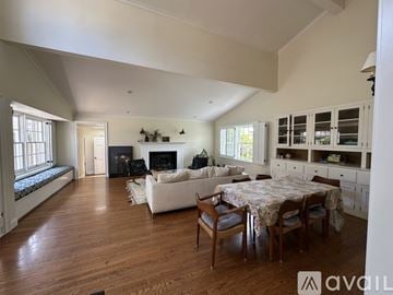 San Diego house for rent - A spacious living room with a fireplace and a dining table set up.