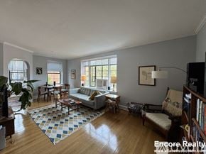 Brookline apartment for rent - A sunny living room with a couch, chairs, and a rug.