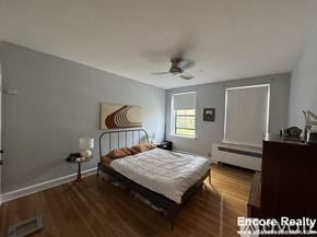 Brookline apartment for rent - A bedroom with a bed, a ceiling fan, and a painting on the wall.