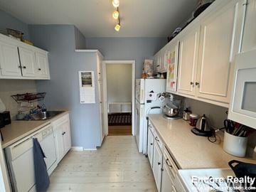 Brookline apartment for rent - A kitchen with white cabinets and a white refrigerator.