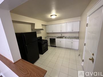 Buffalo apartment for rent - A kitchen with black appliances and white cabinets.