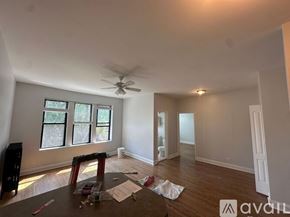 Chicago apartment for rent - A room with a ceiling fan and a window with blinds.