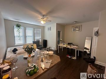 Chicago apartment for rent - A living room with a dining table set for two and a kitchen area.