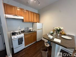 Chicago apartment for rent - A kitchen with wooden cabinets and a white refrigerator.