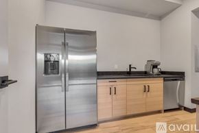 Winter Park apartment for rent - A stainless steel refrigerator in a kitchen with wooden cabinets.
