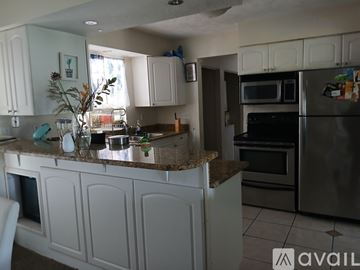 Altamonte Springs house for rent - A kitchen with white cabinets and granite countertops.