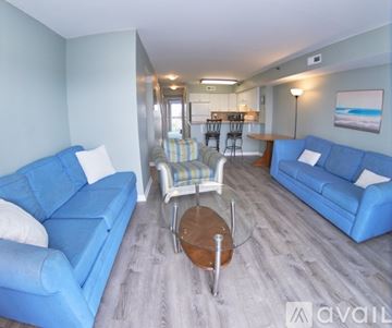 Ocean City apartment for rent - A living room with blue couches and a wooden coffee table.