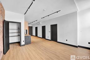 Scranton apartment for rent - A room with a brick wall and wooden floors has a large open door.