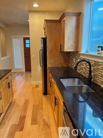 Beaverton house for rent - A kitchen with wooden cabinets and a black countertop.