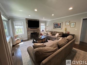 Thornwood house for rent - A living room with a large couch and a fireplace.