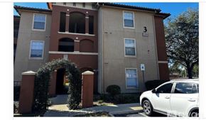 Orlando apartment for rent - A white car is parked in front of a building with a number 3 on it.