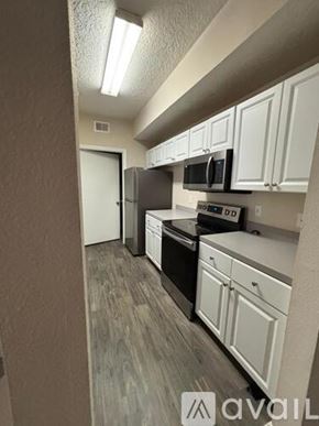 Orlando apartment for rent - A kitchen with white cabinets and a black microwave.