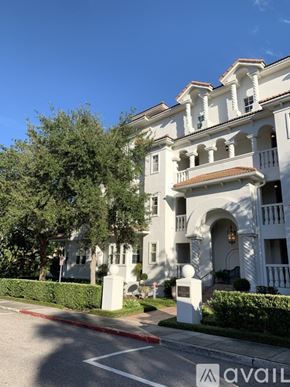 Winter Park apartment for rent - A white building with a balcony and a tree in front of it.