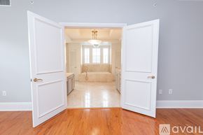 Winter Park apartment for rent - A room with a wooden floor and white walls is shown through an open door.