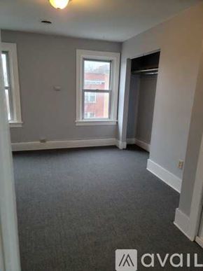 Albany apartment for rent - A room with grey carpet and a window overlooking a red building.