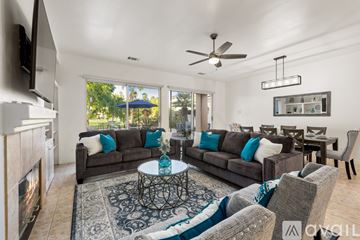La Quinta house for rent - A living room with a grey couch and a fireplace.