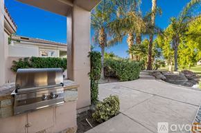 La Quinta house for rent - A backyard with a grill and palm trees.