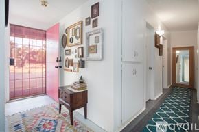 Joshua Tree house for rent - A hallway with a rug and pictures on the wall.
