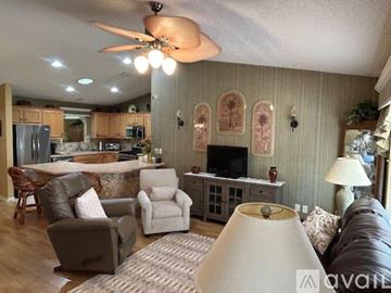 The Villages house for rent - A living room with a brown couch and a white lamp.