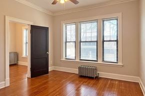 Oak Park apartment for rent - A room with a black door and a ceiling fan.